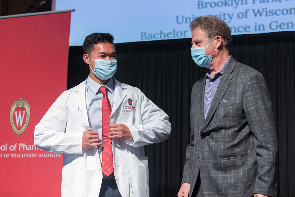 Student wearing their white coat on-stage