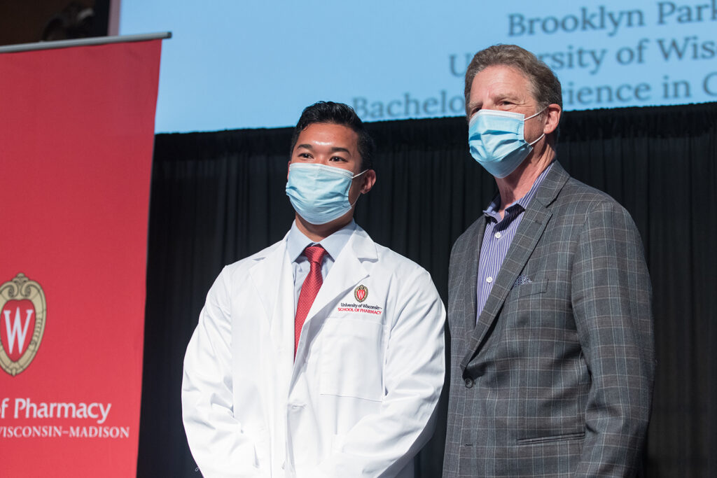 Student wearing their white coat on-stage