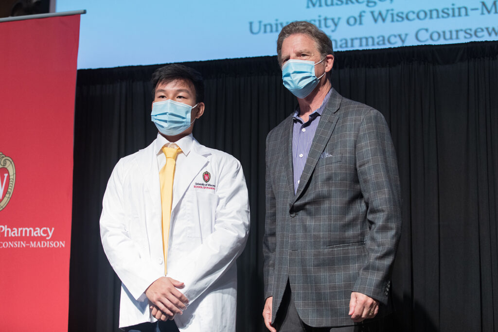 Student wearing their white coat on-stage