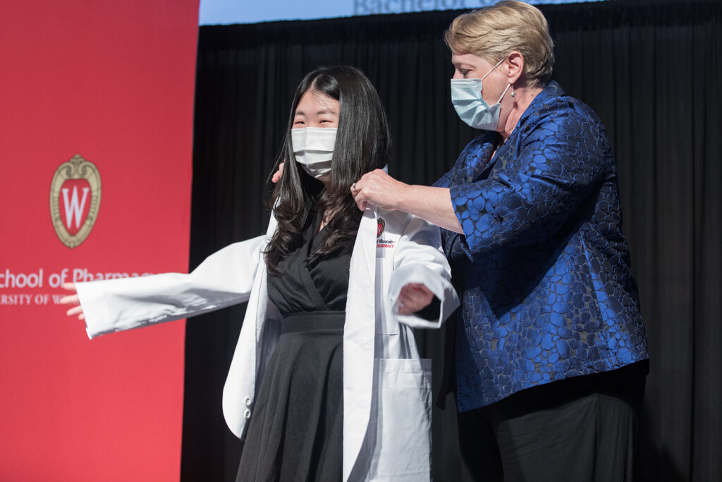Student wearing their white coat on-stage