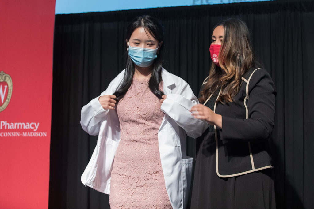 Student wearing their white coat on-stage