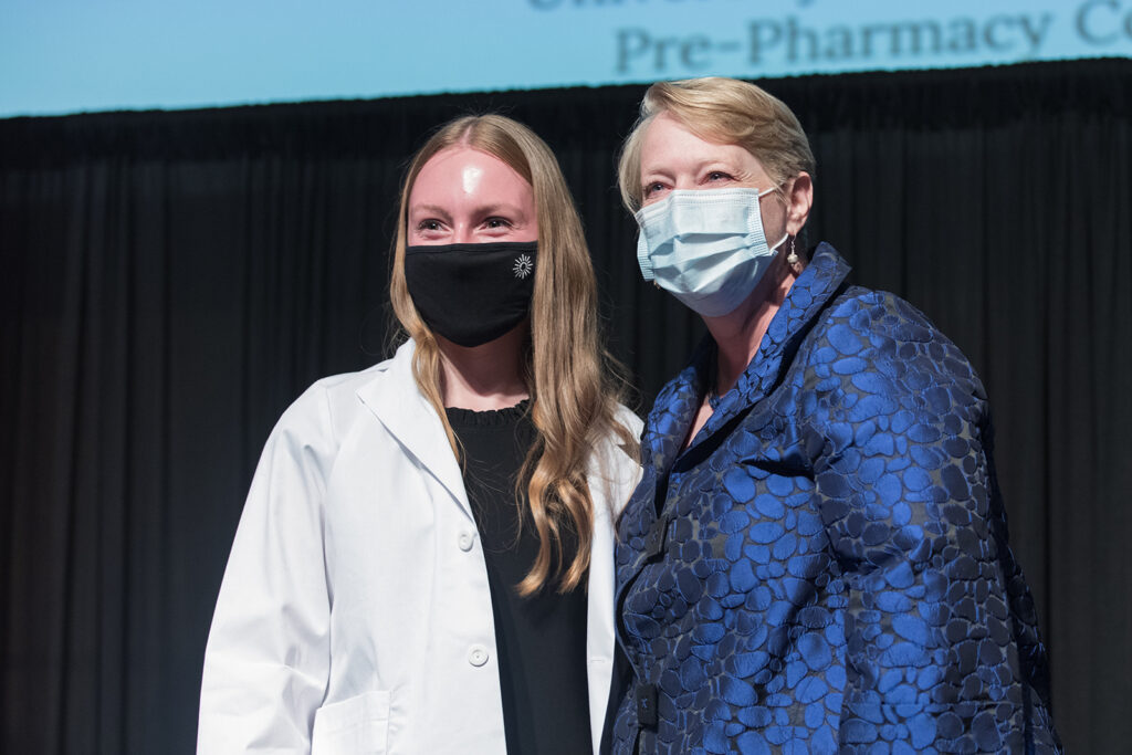 Student wearing their white coat on-stage