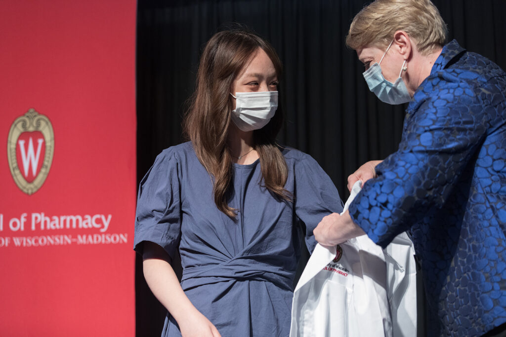 Student wearing their white coat on-stage