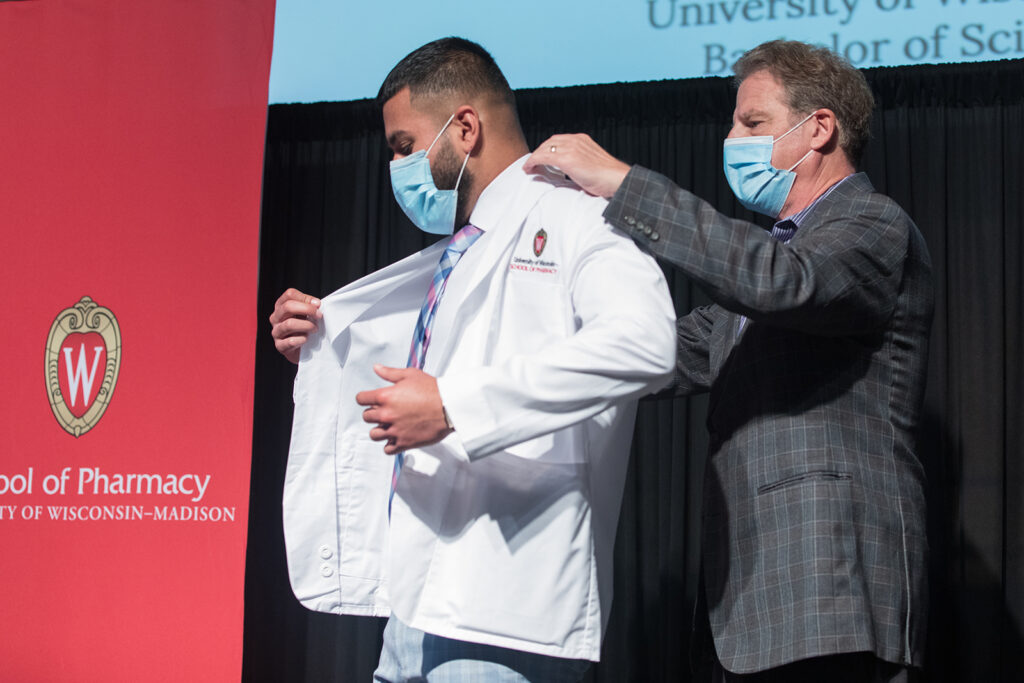 Student wearing their white coat on-stage