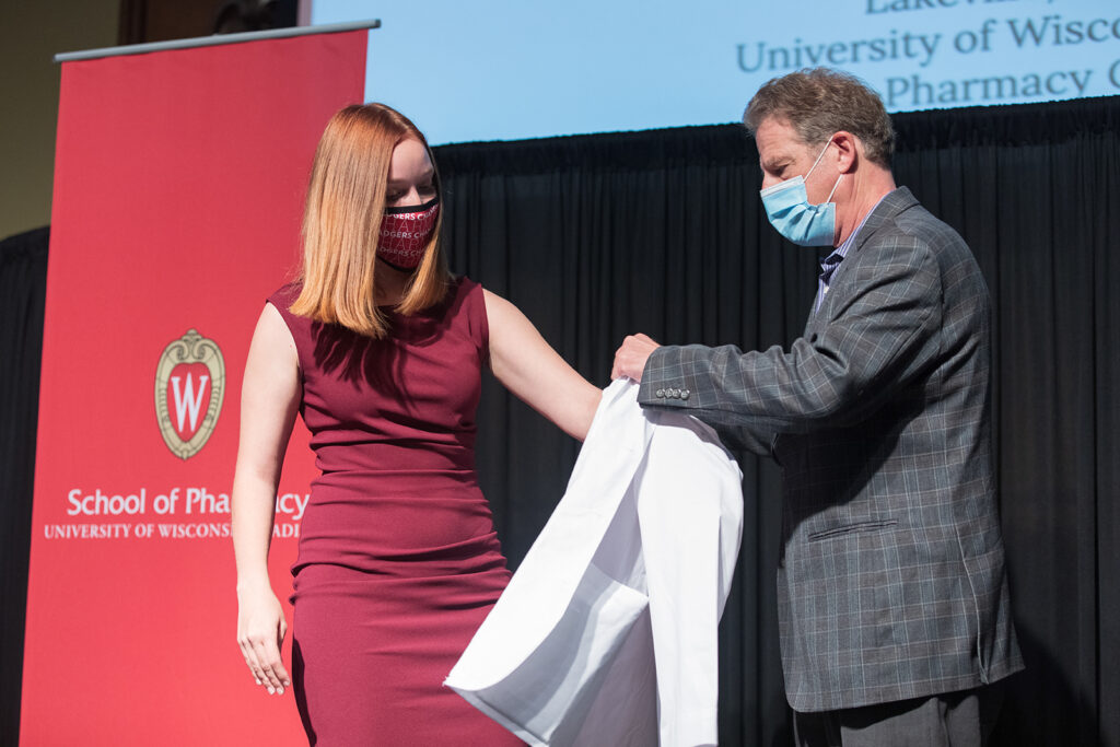 Student wearing their white coat on-stage