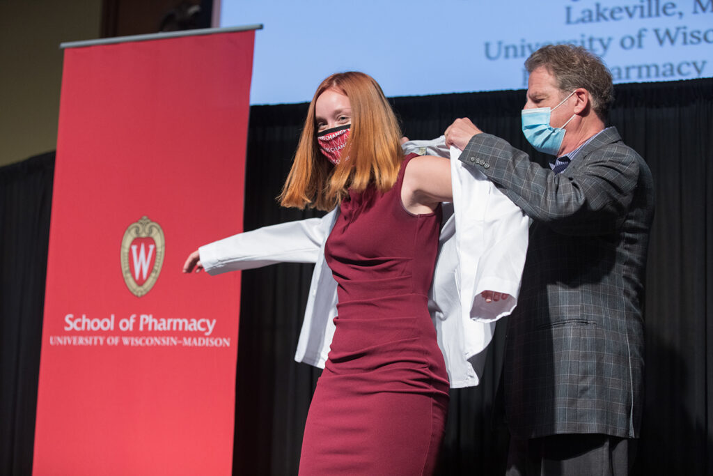 Student wearing their white coat on-stage