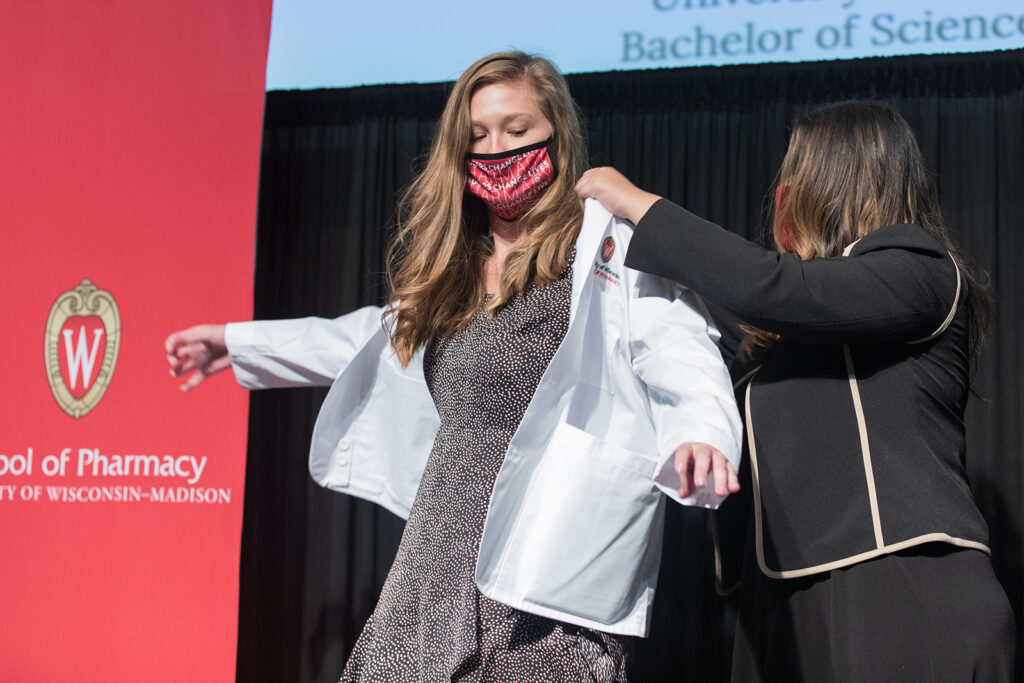 Student wearing their white coat on-stage