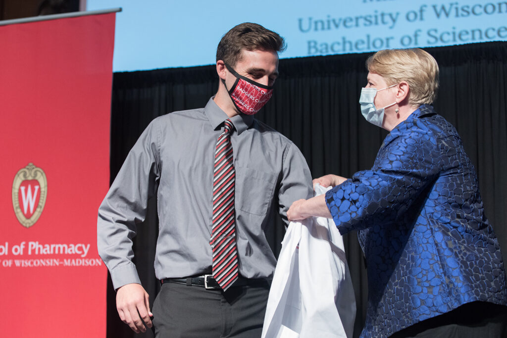 Student wearing their white coat on-stage