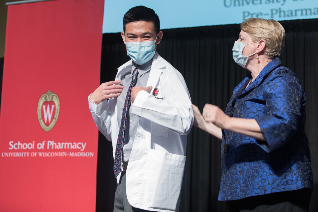 Student wearing their white coat on-stage