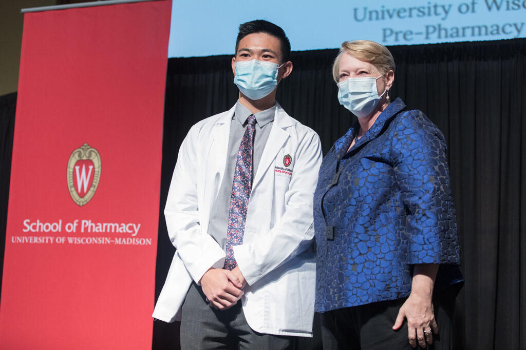 Student wearing their white coat on-stage