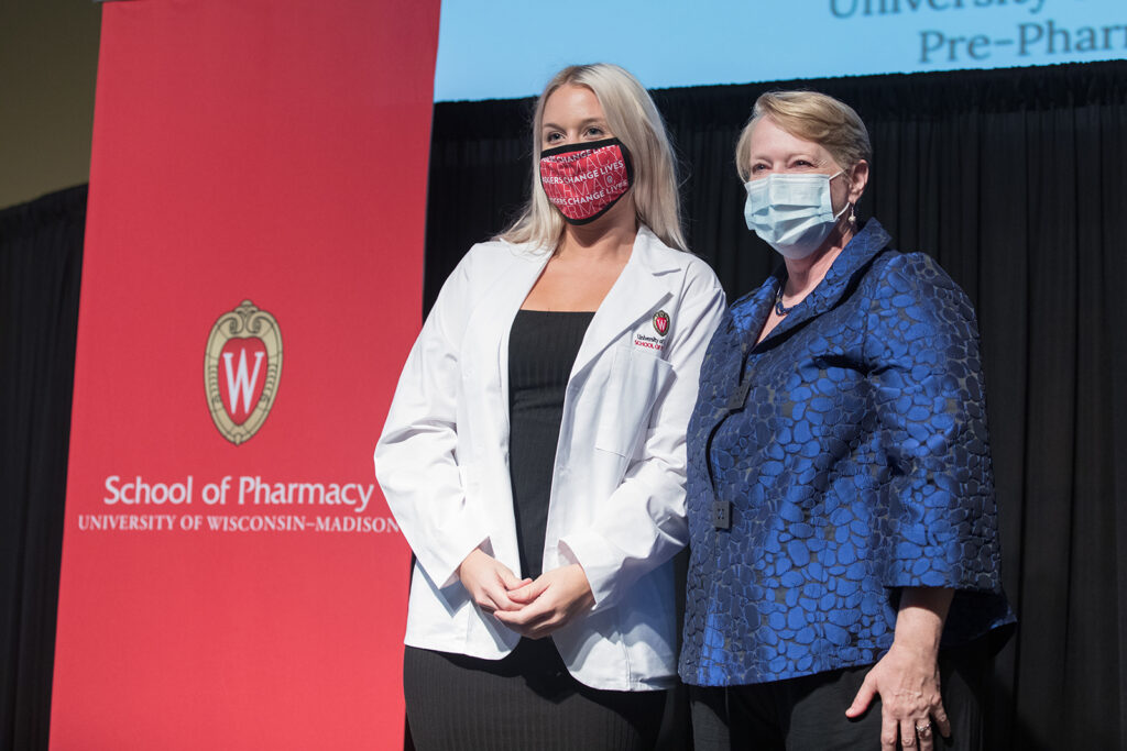 Student wearing their white coat on-stage