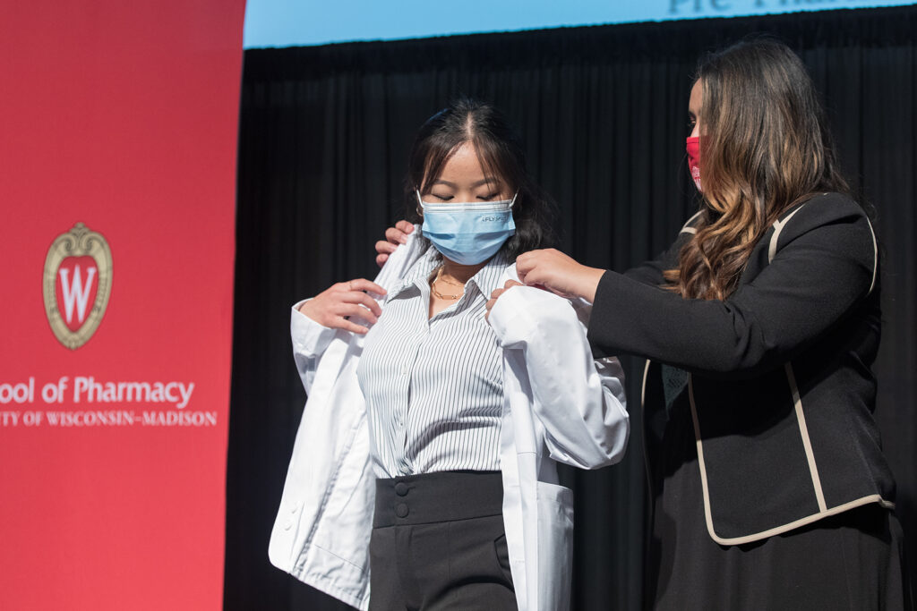 Student wearing their white coat on-stage