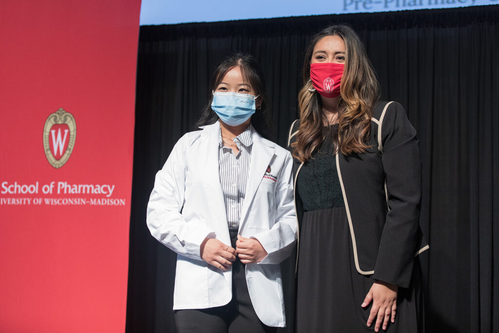 Student wearing their white coat on-stage
