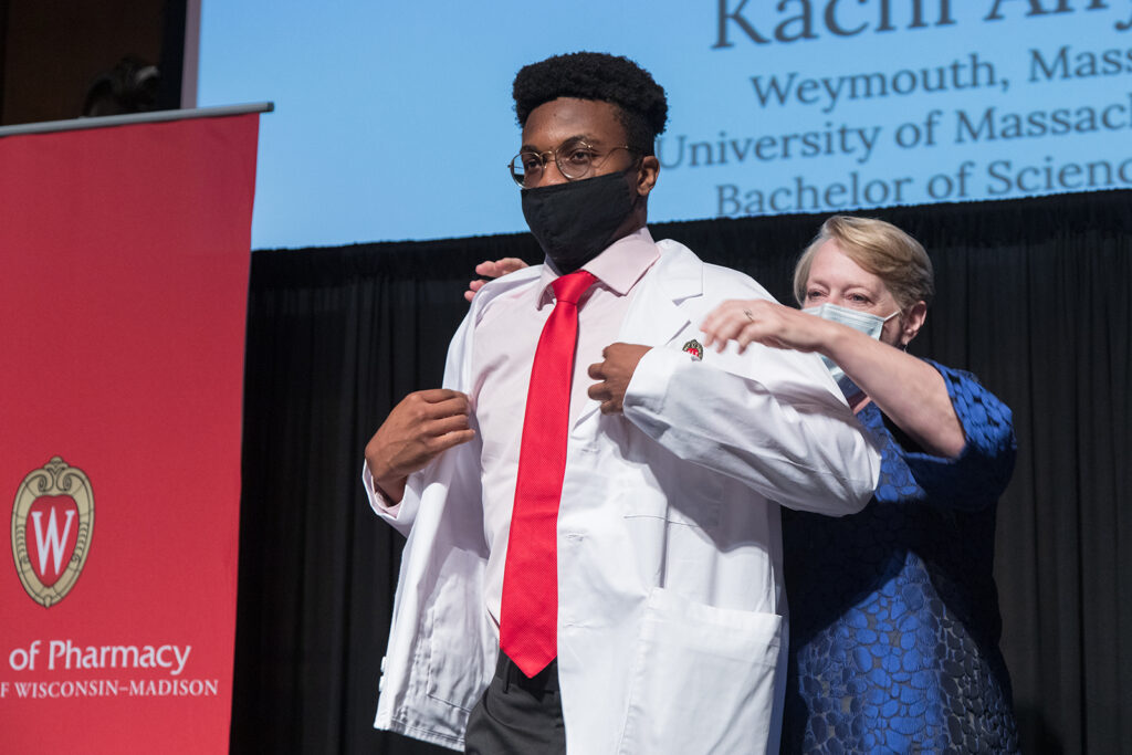 Student wearing their white coat on-stage