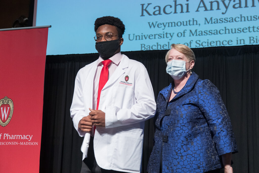 Student wearing their white coat on-stage