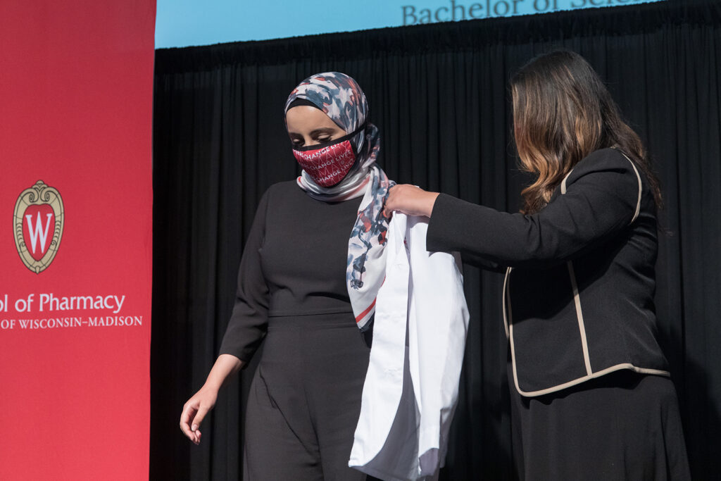 Student wearing their white coat on-stage