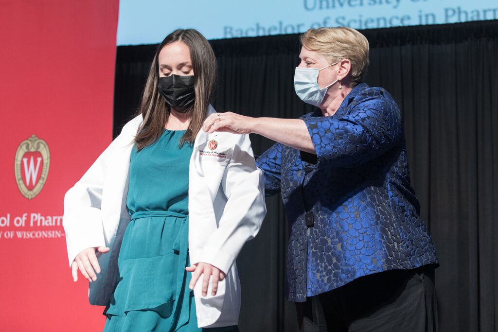 Student wearing their white coat on-stage