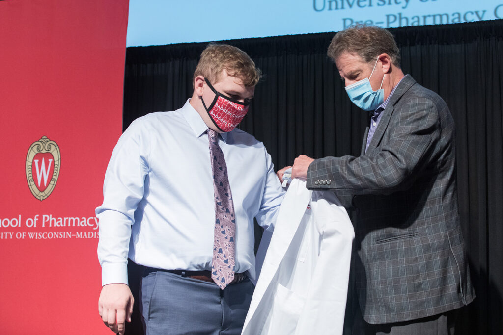 Student wearing their white coat on-stage