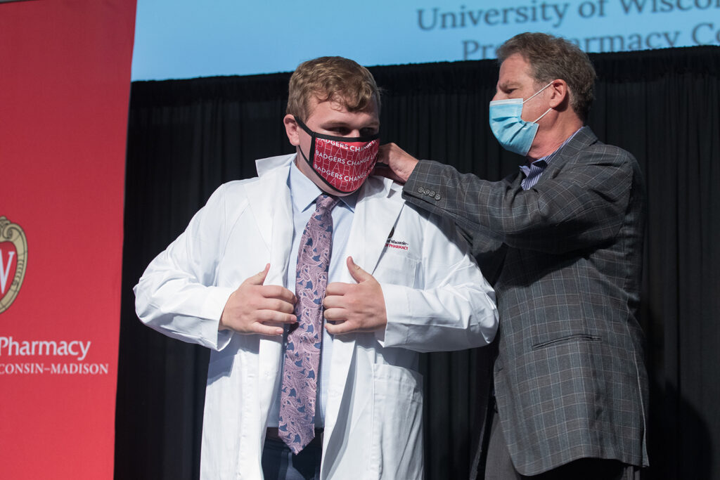 Student wearing their white coat on-stage