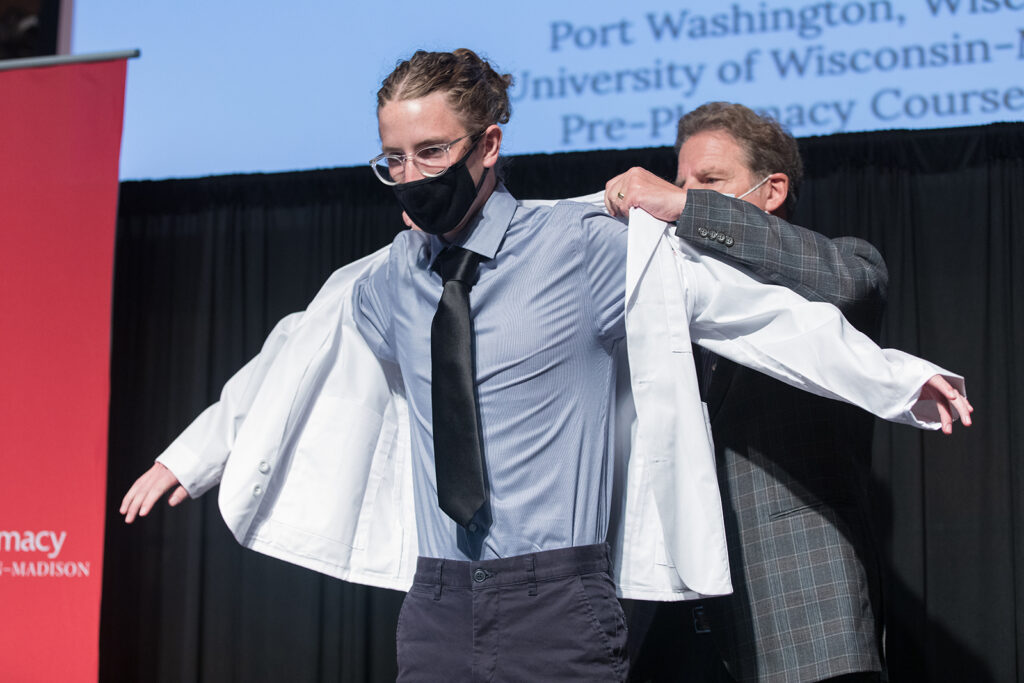 Student wearing their white coat on-stage