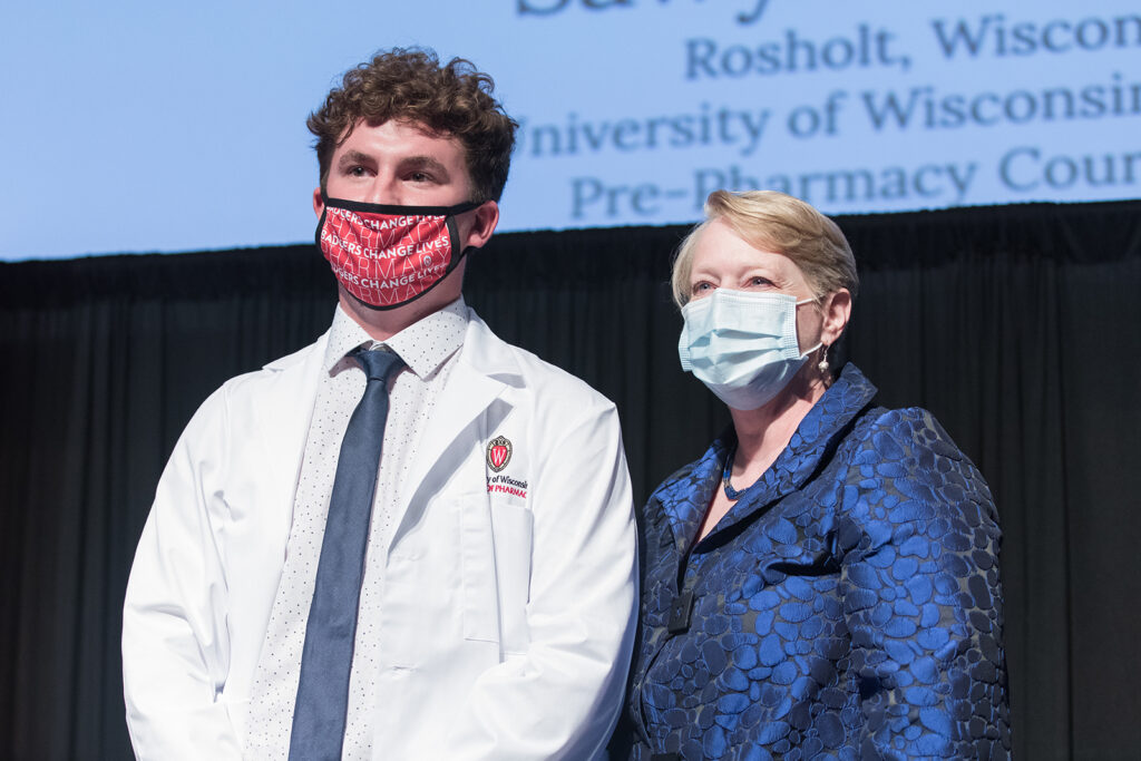 Student wearing their white coat on-stage