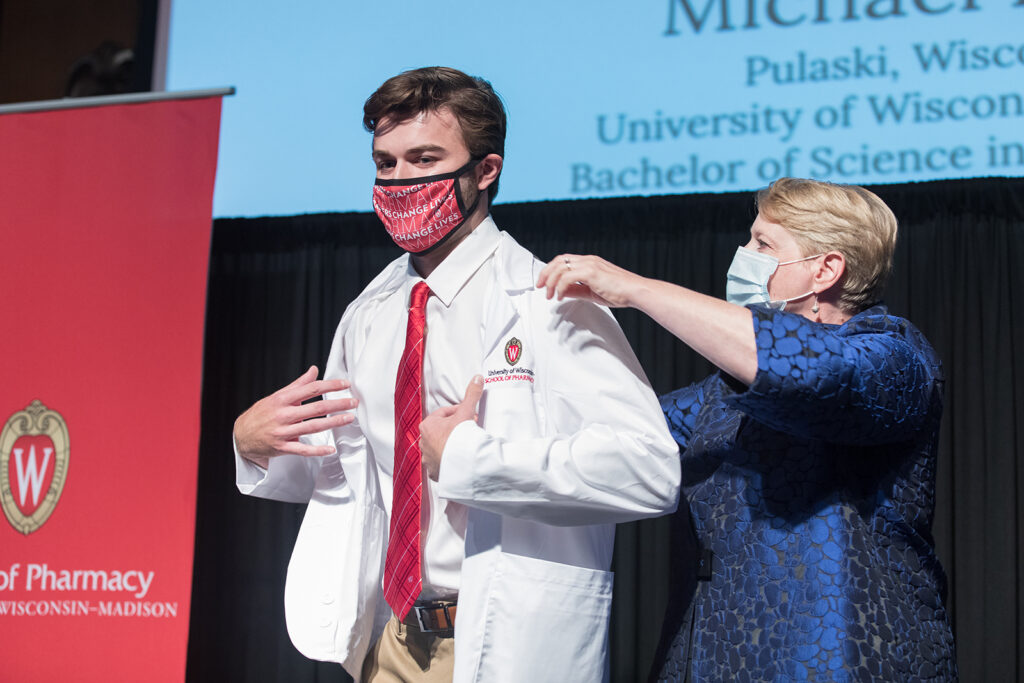 Student wearing their white coat on-stage
