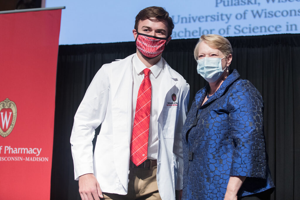 Student wearing their white coat on-stage