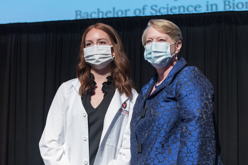 Student wearing their white coat on-stage