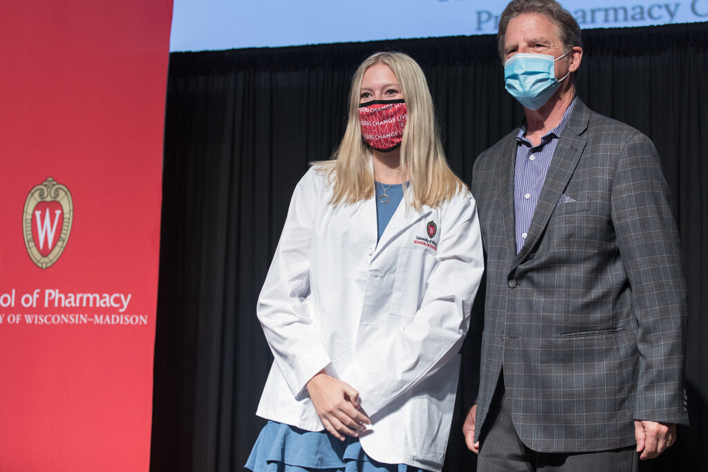 Student wearing their white coat on-stage
