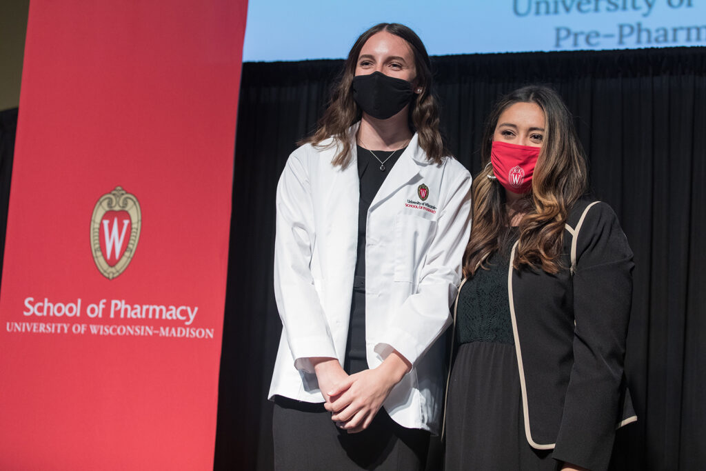 Student wearing their white coat on-stage