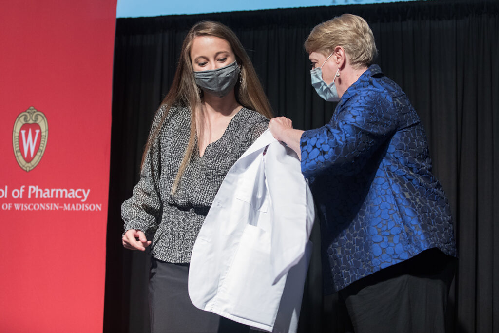 Student wearing their white coat on-stage