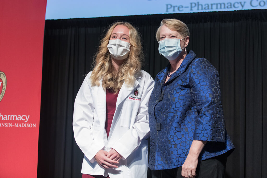 Student wearing their white coat on-stage