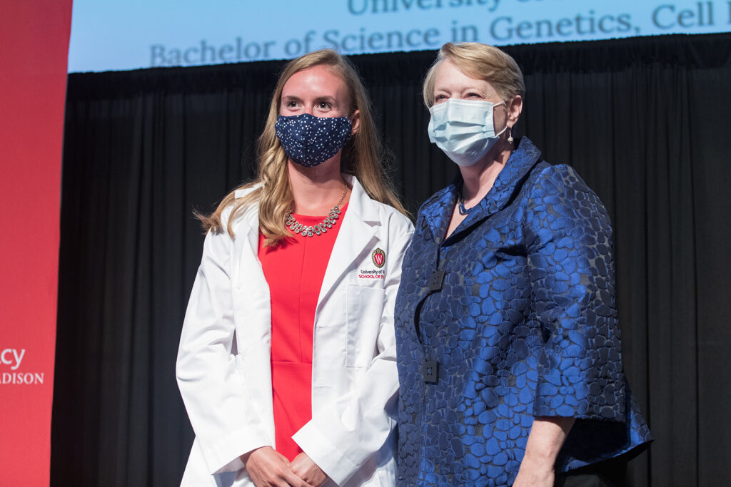 Student wearing their white coat on-stage
