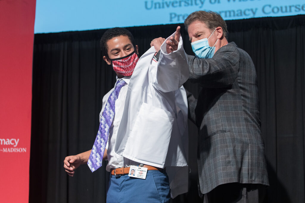 Student wearing their white coat on-stage
