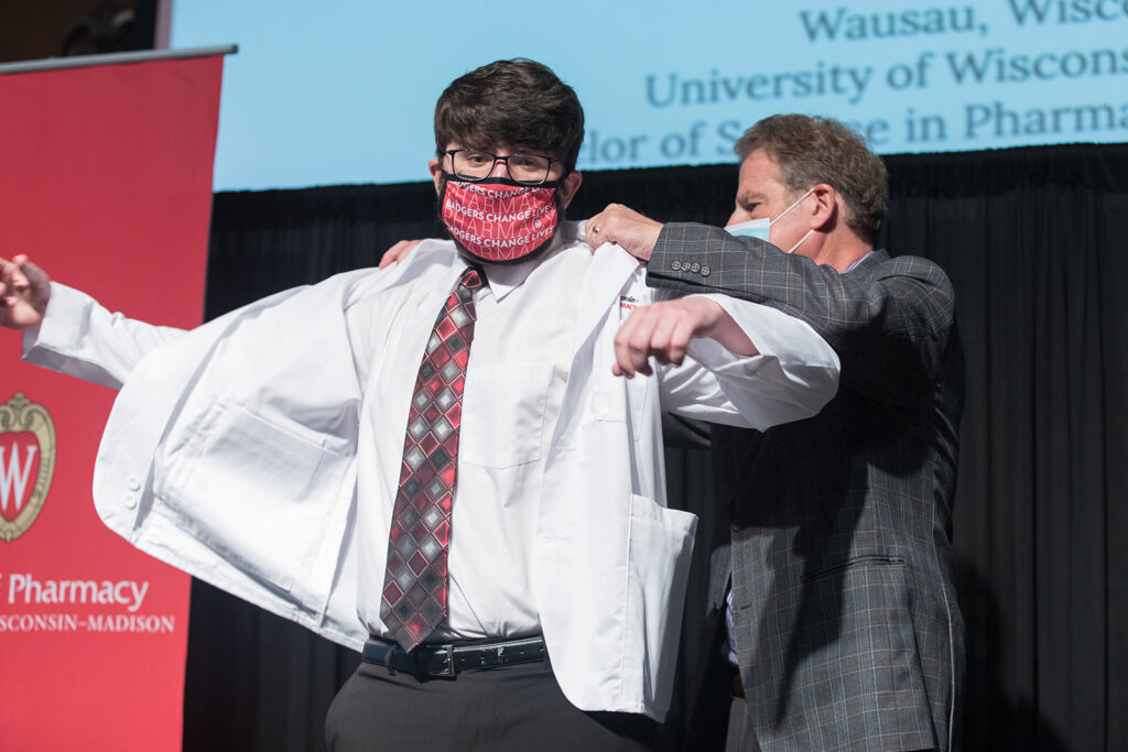 Student wearing their white coat on-stage