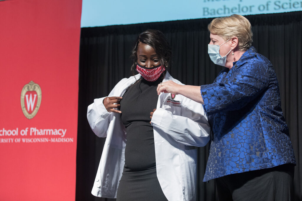 Student wearing their white coat on-stage