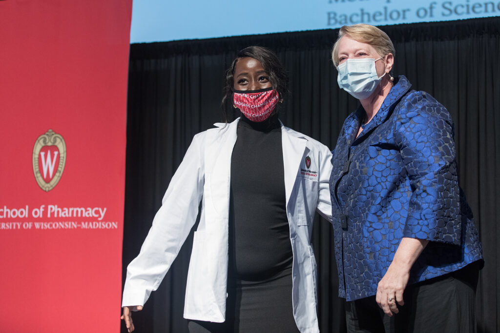 Student wearing their white coat on-stage