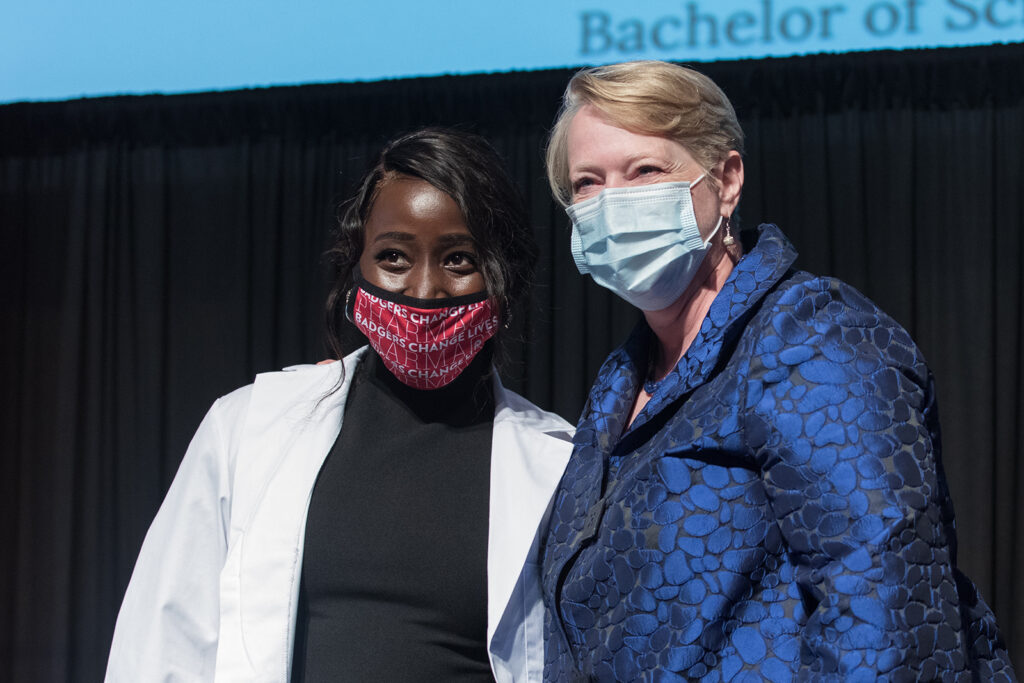 Student wearing their white coat on-stage