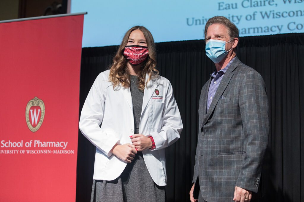 Student wearing their white coat on-stage