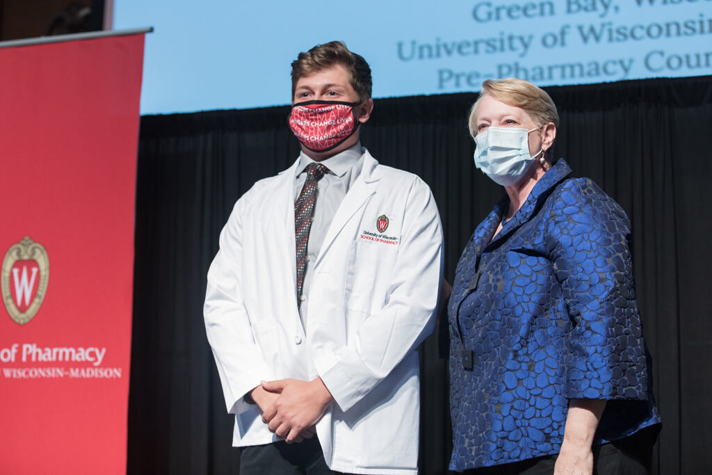 Student wearing their white coat on-stage