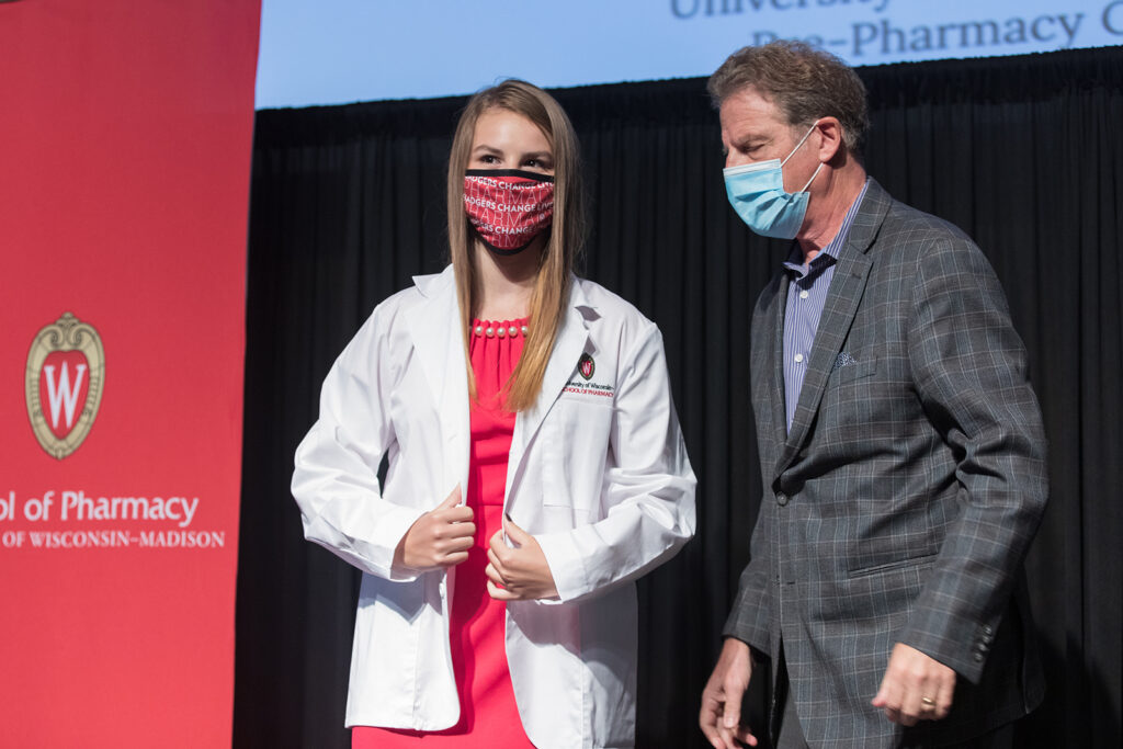 Student wearing their white coat on-stage