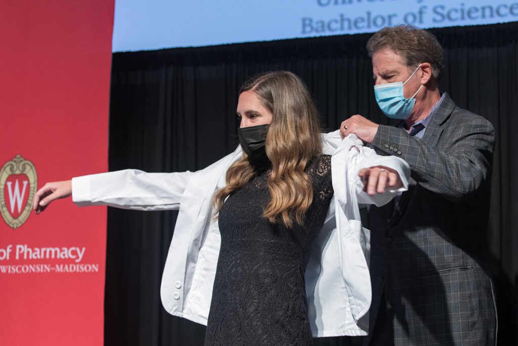 Student wearing their white coat on-stage