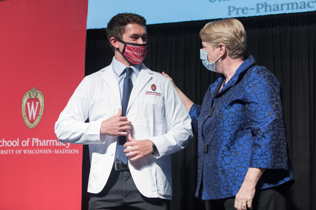 Student wearing their white coat on-stage
