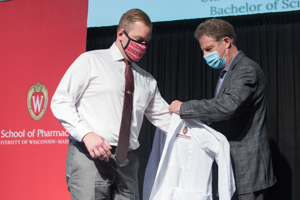 Student receiving their white coat on-stage
