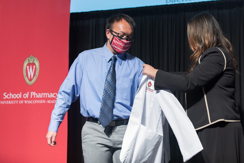 Student receiving their white coat on-stage