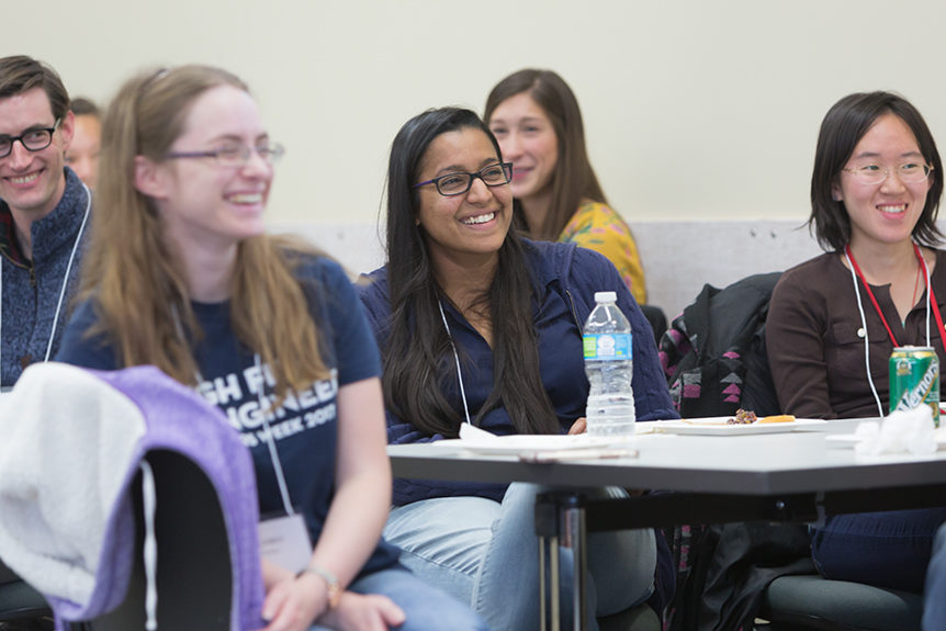 Students smiling at tables