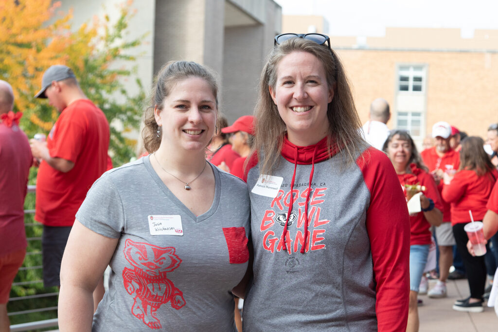 Two alumni standing arm-in-arm