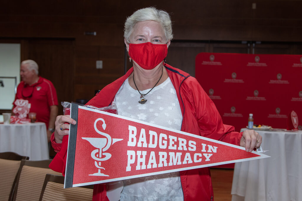 SoP alumni holding up "Badgers in Pharmacy" prop