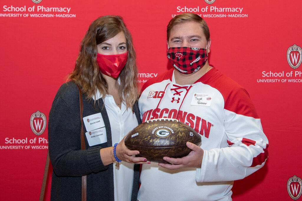 Alumni holding signed Greenbay Packers football