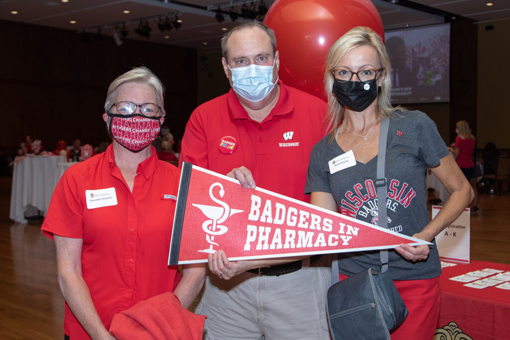 Alumni event coordinators holding up "Badgers in Pharmacy" prop